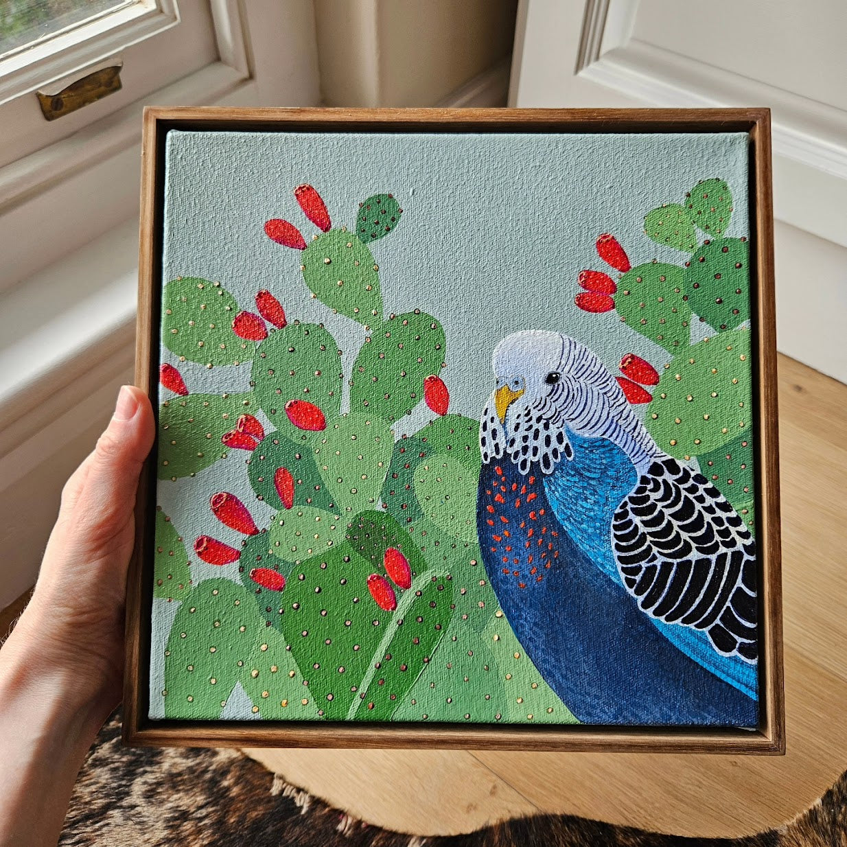 budgie in prickly pears (framed)